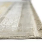 A close-up of a Qaleen Carpets rug's edge, with a focus on the fringe and the rug's design