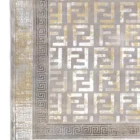 A close-up of a Qaleen Carpets rug with a traditional design, featuring a mix of gold and silver patterns on a grey