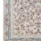 A close-up of a Qaleen Carpets rug with a floral pattern on a beige background, featuring a border with intricate designs