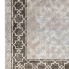 A close-up of a Qaleen Carpets rug with a geometric pattern and a border, showcasing the intricate design and quality of the
