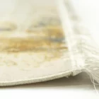 A close-up of a Qaleen Carpets rug's edge, with a focus on the intricate weaving and the soft, white and gold colors of the