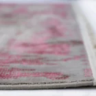 A close-up of a Qaleen Carpets rug, with a focus on the intricate patterns and textures of the carpet's edge, showcasing the