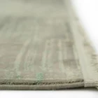 A close-up of a Qaleen Carpets rug with a subtle, muted color palette and a soft, woven texture