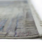 A close-up of a Qaleen Carpets rug with a subtle, intricate design and a soft, muted color palette