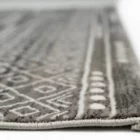 A close-up of a gray and white area rug with a geometric pattern, made by Qaleen Carpets