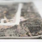 A close-up of a rug's edge, with a focus on the intricate design and the Qaleen Carpets brand