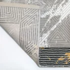 Qaleen Carpets A close-up of a rug's corner, with a patterned design and a white background