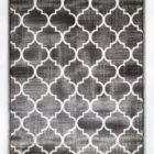 A high-quality, close-up image of a Qaleen Carpets rug with a repeating, white, four-leaf pattern on a dark, grey background