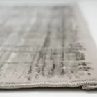 A close-up of a light grey and white woven carpet with a subtle, intricate pattern, made by Qaleen Carpets