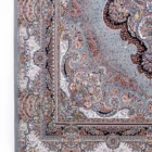 A close-up of a Qaleen Carpets rug with intricate patterns and a rich, vibrant color palette, showcasing the company's