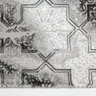 A close-up of a Qaleen Carpets rug with a repeating pattern of intricate, ornate designs in a mix of white, grey, and black,