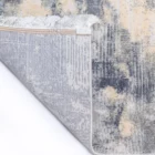 A close-up of a Qaleen Carpets rug's edge, with a subtle pattern and soft, white fringe