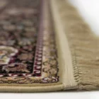 A close-up view of a Qaleen Carpets rug, showcasing its intricate design and fringe details