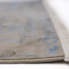 A close-up of a Qaleen Carpets rug's edge, with a focus on the fringe and the carpet's design, showcasing its quality and