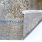 Qaleen Carpets' stunning rug with a mix of gold, blue, and white colors