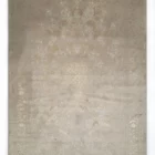 A Qaleen Carpets rug with a light grey background and intricate, white, floral patterns