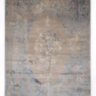 A Qaleen Carpets rug with a distressed, vintage-inspired design in a neutral color palette, featuring a central medallion