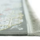 A close-up of a rug's edge, with a soft, muted color palette and intricate patterns, showcasing the beauty of carpets and