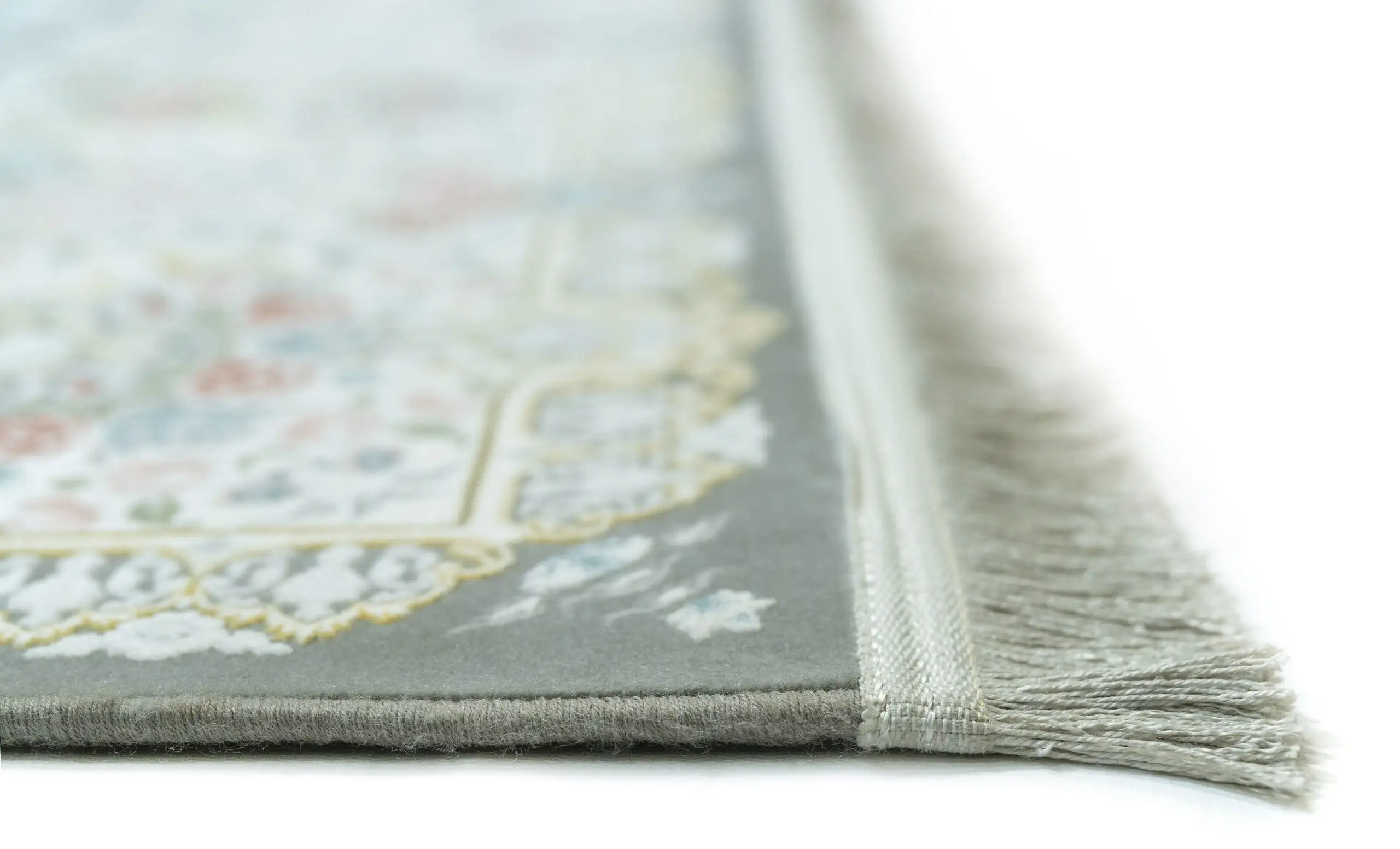 A close-up of a rug's edge, with a soft, muted color palette and intricate patterns, showcasing the beauty of carpets and