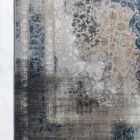Qaleen Carpets A close-up of a rug with a mix of blue, white, and brown patterns, with a frayed blue edge and a white