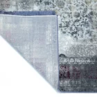 A corner of a rug with a mix of red, white, and grey patterns, with a frayed edge and a subtle sheen, made by Qaleen Carpets