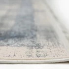A close-up of a Qaleen Carpets rug with a subtle, intricate design and a soft, neutral color palette