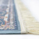 A close-up view of a blue and white rug with a fringe on one edge, showcasing its intricate design and high-quality