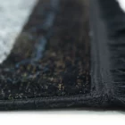 A close-up of a black and white rug with a fringe on a white background, made by Qaleen Carpets