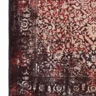 A close-up of a Qaleen Carpets rug with a red and cream pattern, featuring a border and a fringe at the bottom