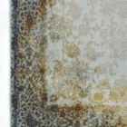 A close-up of a Qaleen Carpets rug with a floral pattern in muted colors, featuring a mix of gold, blue, and brown hues on a