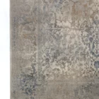 A close-up of a Qaleen Carpets rug with a traditional, intricate design and a soft, muted color palette