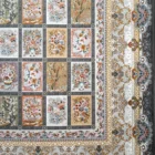 A beautiful, intricately designed carpet with a mix of flowers, trees, and other patterns, showcasing the art of carpets and