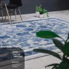Carpets A beautiful, blue and white, patterned carpet on a grey floor, with a chair and a plant in the background