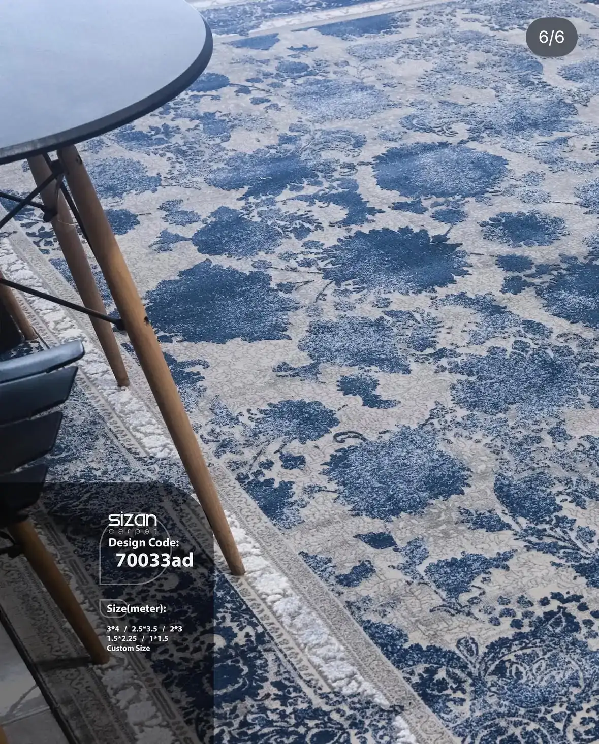 Qaleen Carpets A blue and white patterned rug with a table and chair on it, with a white tablecloth and a blue chair with a