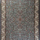 A Qaleen Carpets rug with a gray background and intricate floral pattern, featuring a border of white and gold, and a fringe