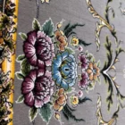 Carpets A close-up of a carpet with a floral pattern, featuring a mix of colors and a soft, carpeted texture