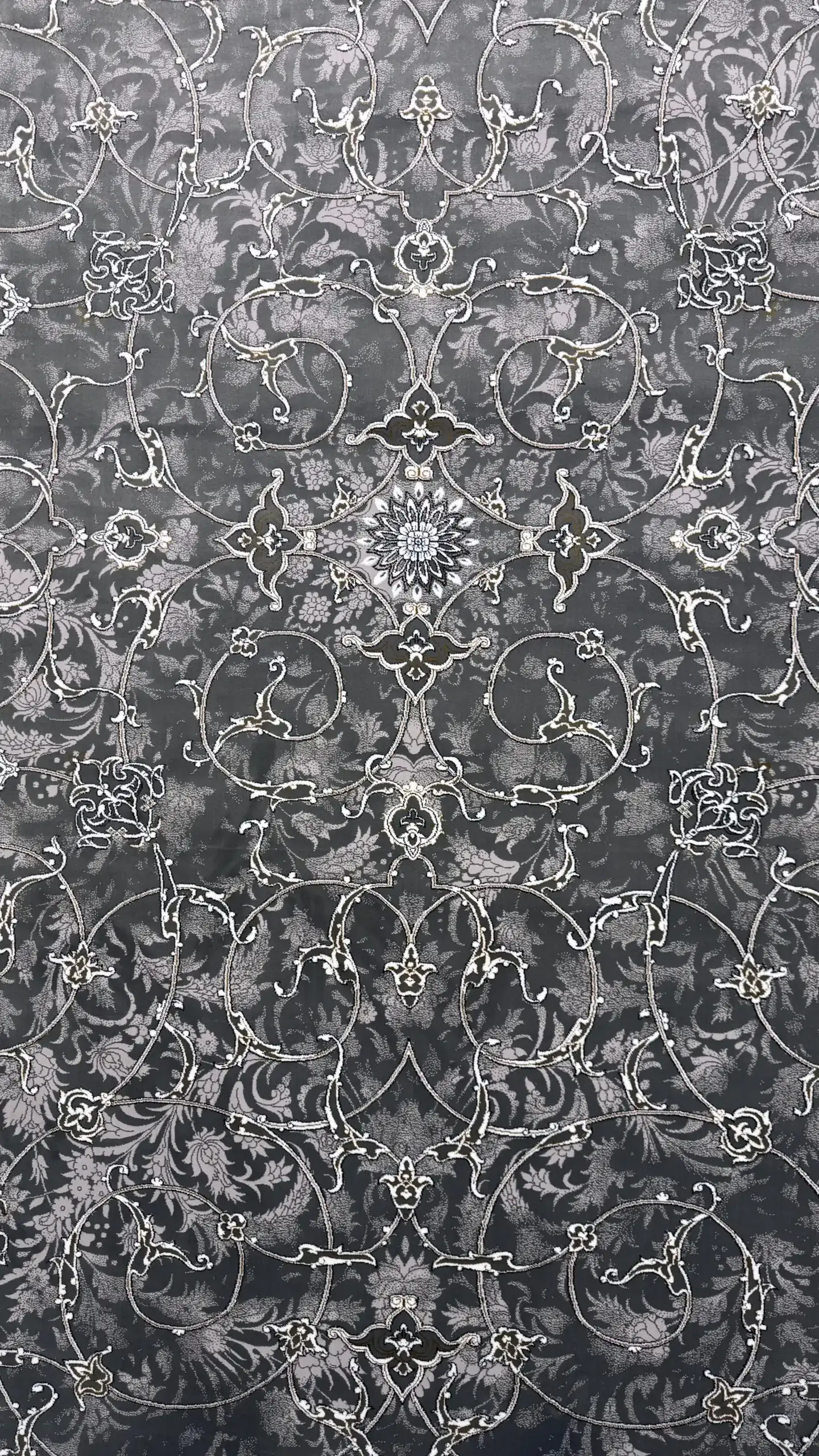 Carpets A close-up of a dark, ornate, and intricate carpet with a pattern of flowers and leaves, with a focus on the